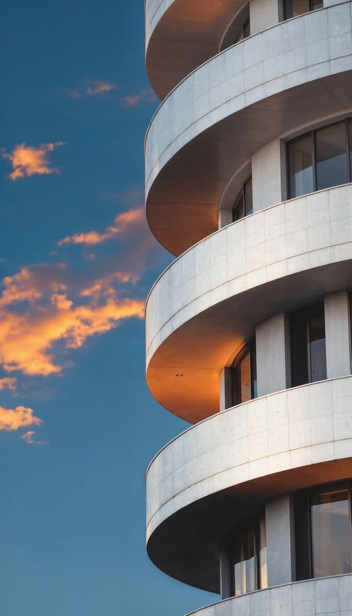 Curved modern building facade with sunset
